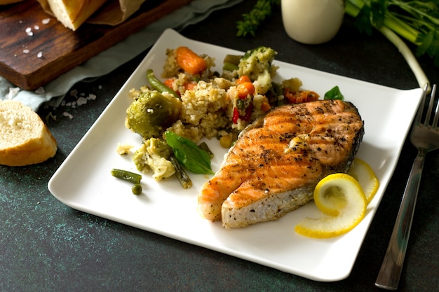 Foto bife de salmão grelhado com cuscuz e vegetais comida saudável