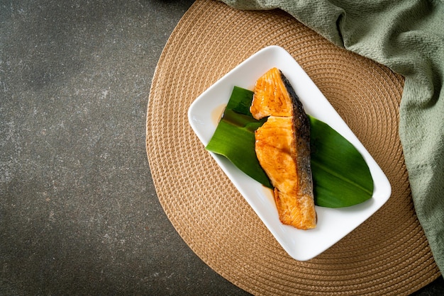 Bife de salmão grelhado com molho de soja no prato - estilo de comida japonesa