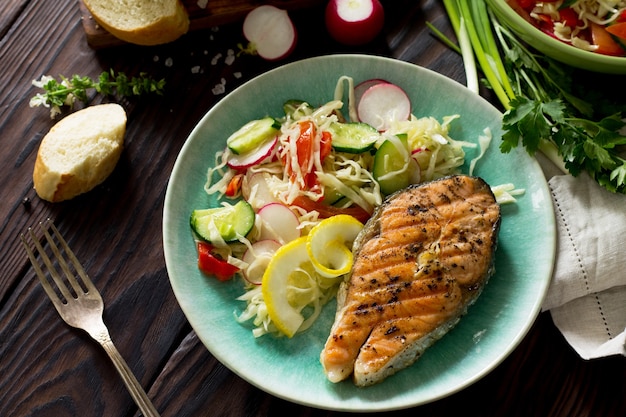 Bife de salmão grelhado e salada de vegetais vegetariana de salada de alface rabanete comida saudável