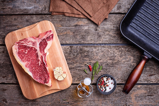 Bife de t-bone cru e panela de grelha de ferro