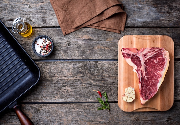 Bife de t-bone cru e panela de grelha de ferro