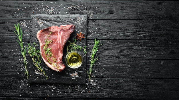 Bife de Tbone cru em uma mesa de madeira Vista superior Espaço livre para texto