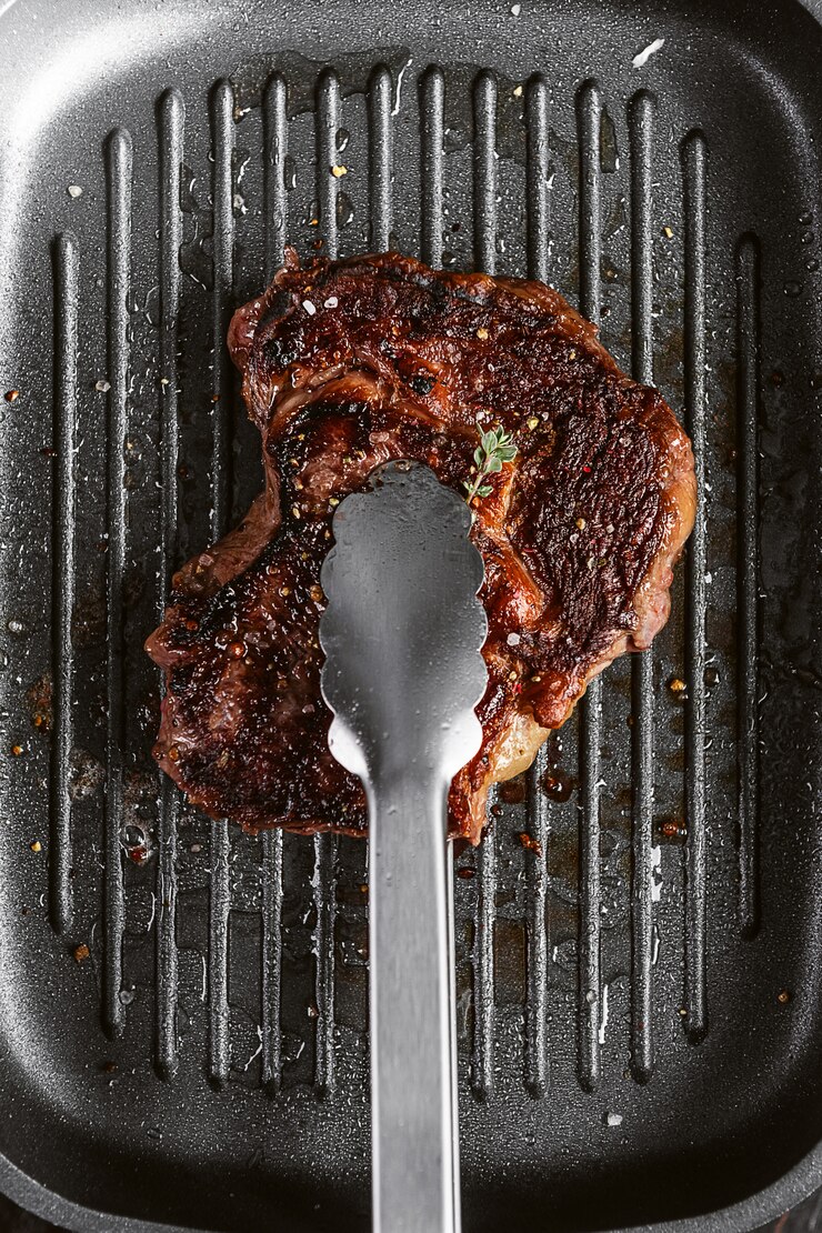 Foto bife de um pedaço fresco de carne de porco frita em uma panela