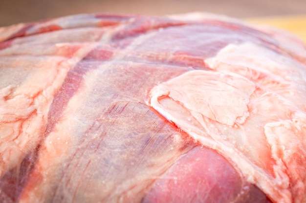 Bife do lombo cru inteiro em uma tábua de madeira sobre uma mesa de madeira