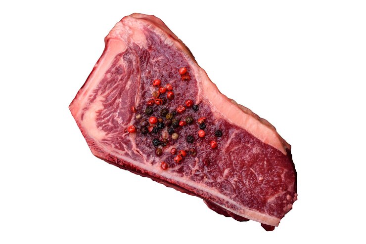 Foto bife fresco, suculento e cru com especiarias e ervas salgadas.
