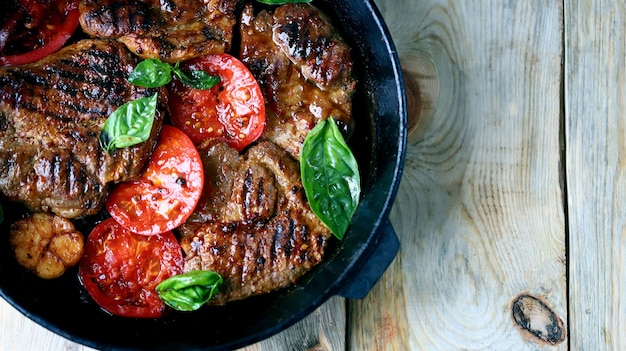 Bife grelhado apetitoso e suculento com vegetais grelhados em uma panela