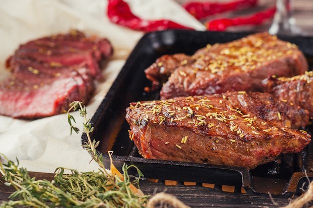 Foto bife grelhado na frigideira, vista superior. pedaços fritos de carne de perto