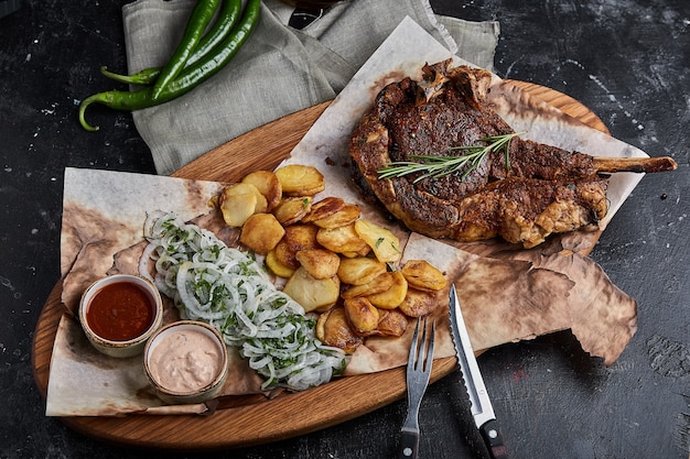 Bife grelhado Tomahawk com cunha de batata frita