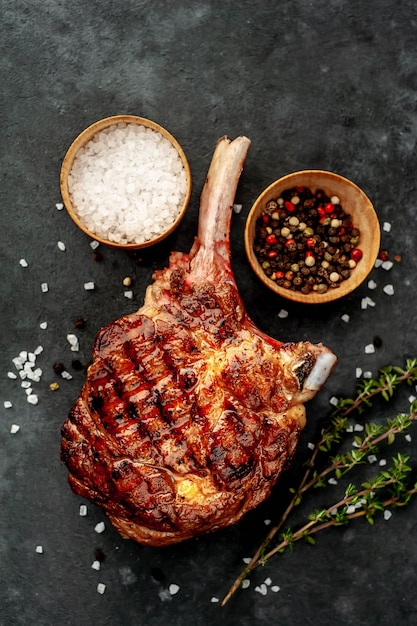 Bife - machado de carne grelhado com especiarias, tomilho sobre um fundo de pedra.