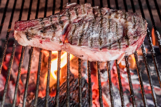 Bife na chapa de metal grelhado sobre o carvão ardente