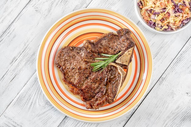 Bife Panfried Tbone com alecrim fresco e pimenta no prato