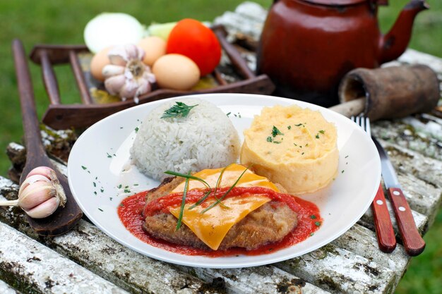 El bife a la parmesana con patata y arroz