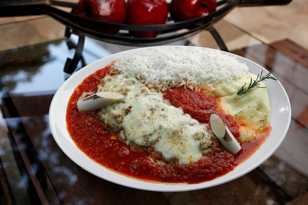 El bife a la parmesana con patata y arroz