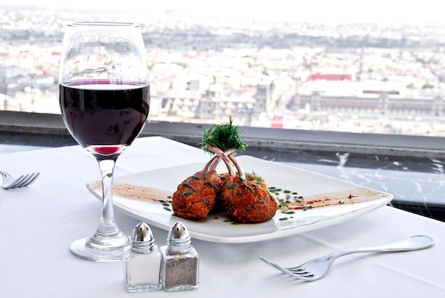 bife, prato de carne e copo de vinho tinto, com vista panorâmica da cidade, comida, gastronomia