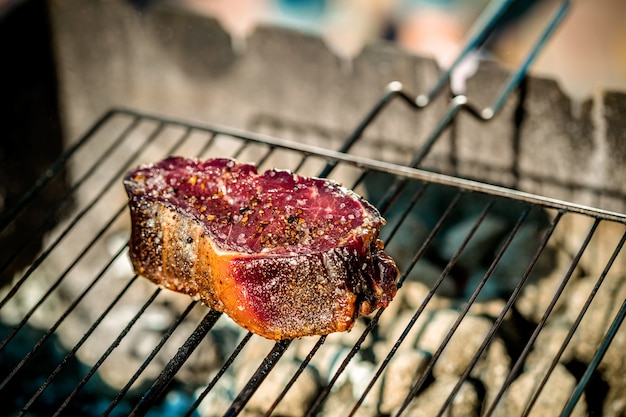 Bife quente picante grelhado em um churrasco de verão sobre as brasas guarnecidas. Cozinhar alimentos. fechar-se