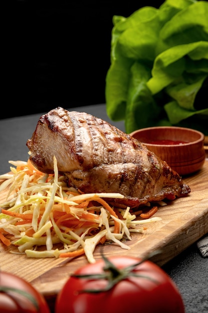 Foto bife servido com chucrute e molho em uma tábua de madeira