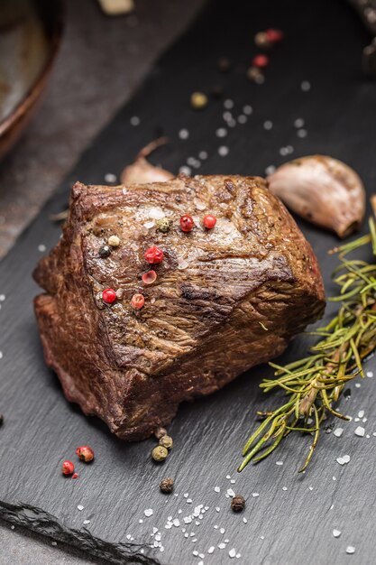 Bife suculento com especiarias e ervas na tábua.