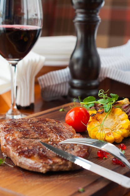 Bife suculento e delicioso em uma tábua de madeira