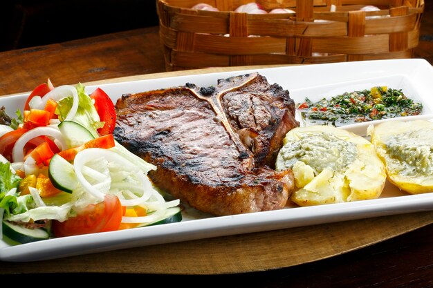 Bife T bone com salada de batata e vegetais