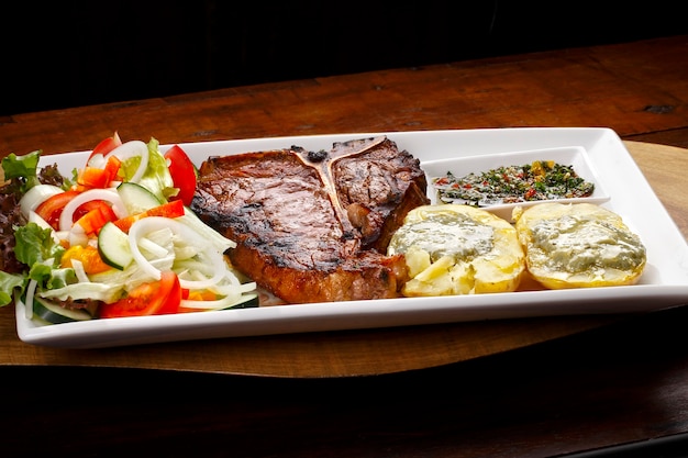 Bife t bone com salada de batata e vegetais