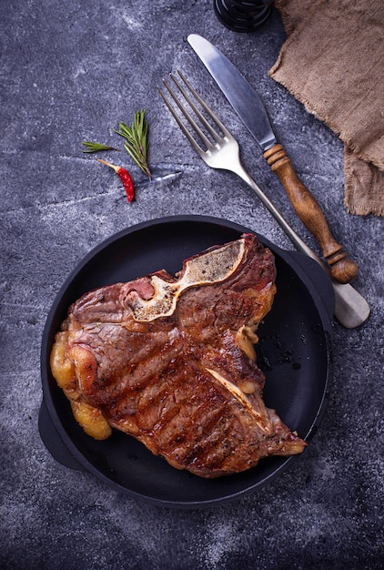 Bife T-bone grelhado em fundo escuro