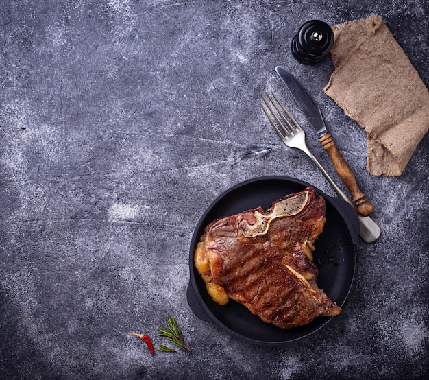 Bife T-bone grelhado em fundo escuro