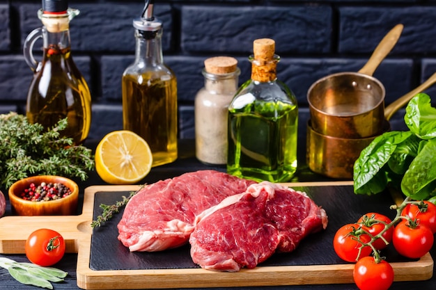 Bifes de carne crua em uma placa de madeira