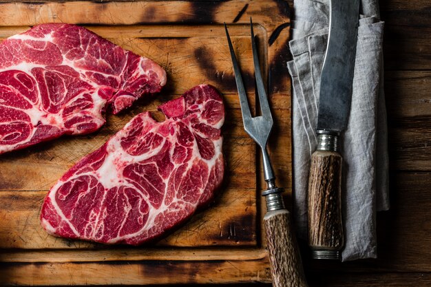 Bifes de carne crua marmorizada na tábua de madeira