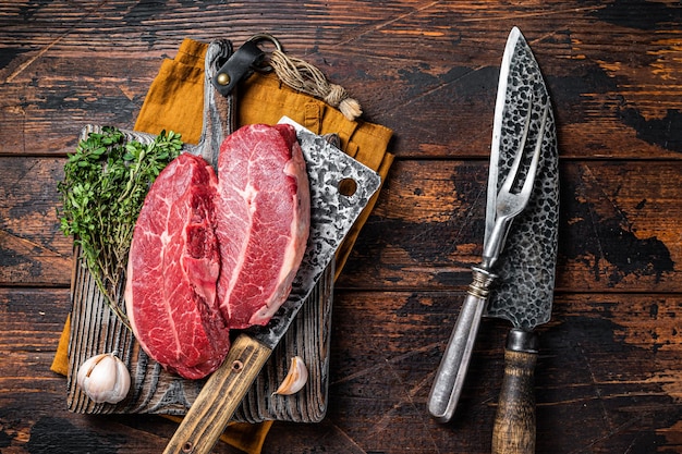 Bifes de carne de bovino de lâmina superior cru envelhecido seco Fundo escuro Vista superior