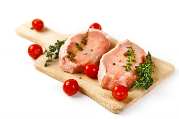 Bifes de carne de porco crua fresca na placa de corte