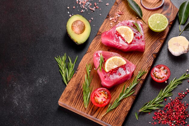 Bifes de filé de atum fresco com especiarias e ervas em um fundo preto