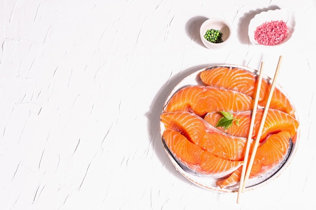 Bifes de filé de peixe fresco cru de salmão ou truta. design minimalista, luz dura moderna, sombra escura. ingredientes refrigerados para cozinhar frutos do mar saudáveis. fundo culinário de massa branca, vista superior