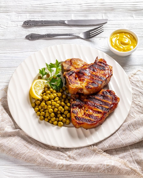 Bifes de lombo de porco grelhados com ervilhas verdes cozidas