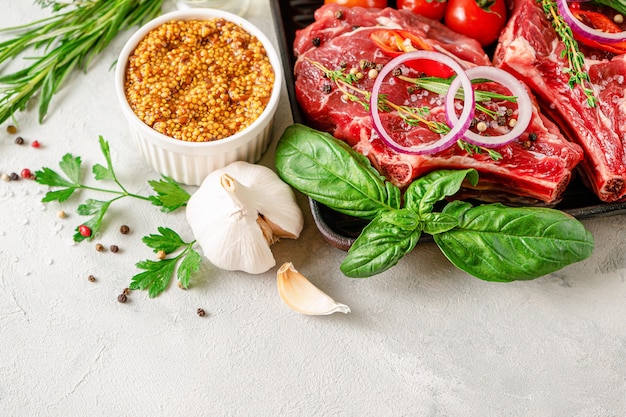 Bifes de osso de vitela fresca com especiarias e ervas em fundo cinza de concreto