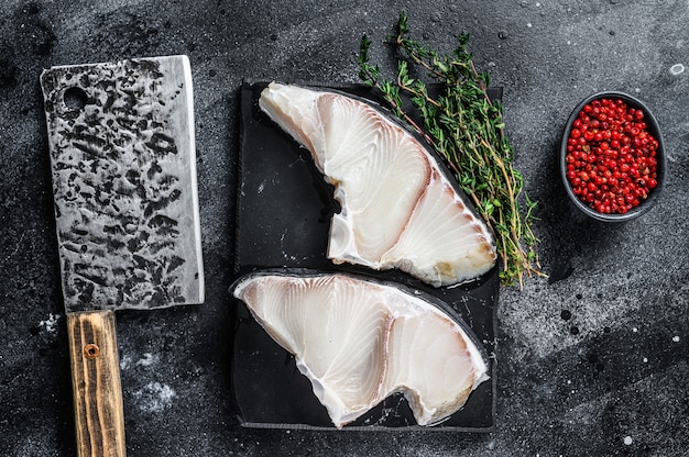 Bifes de peixe de tubarão cru em uma placa.