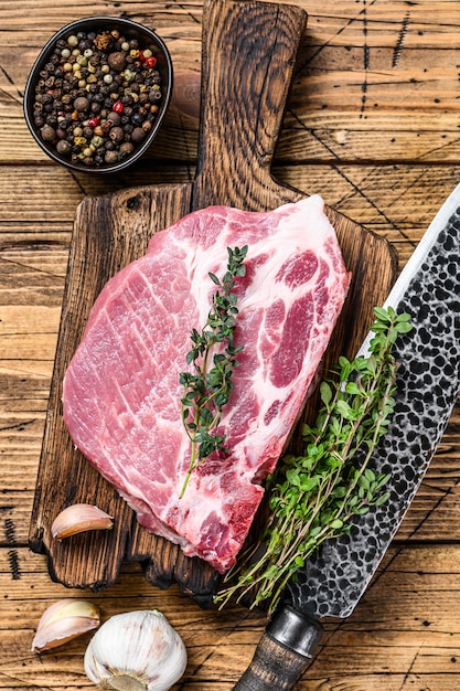 Foto bifes de porco em uma tábua de cortar carne crua e fresca com faca