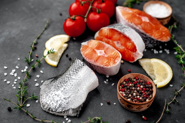 bifes de salmão cru frescos e cauda de salmão com sal, pimenta, tomate, limão