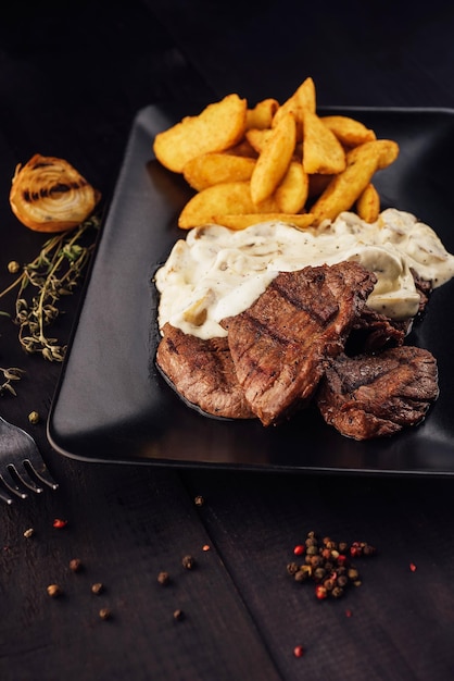 Bifes grelhados com molho de cogumelos e batatas fritas