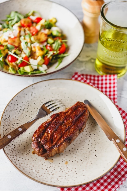 Bifes grelhados e salada de legumes na luz.