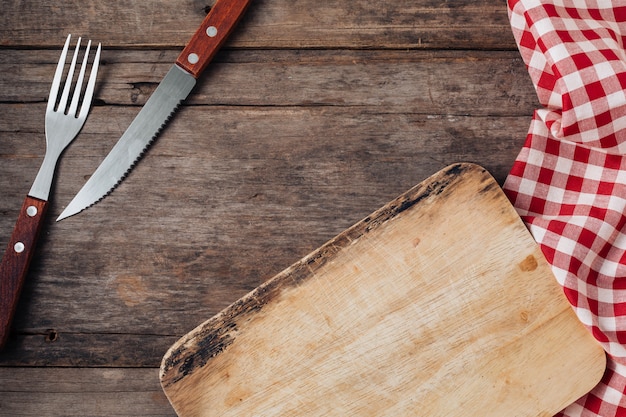 Bifurcación y cuchillo de la carne en fondo de madera