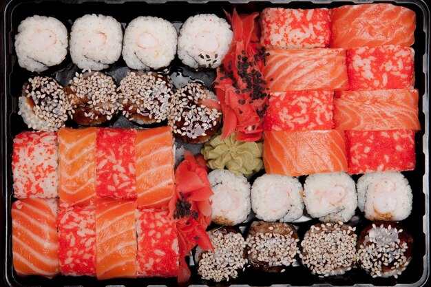 Big Sushi Set ib schwarze Plastikbox auf weißem Hintergrund, Draufsicht Nahaufnahme, Kopienraum