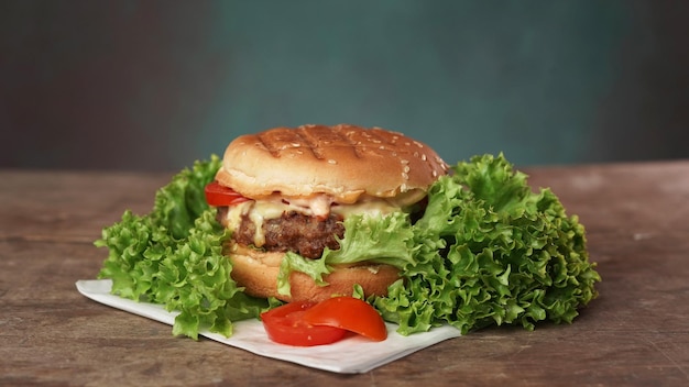 Big Tasty Beef Patty Burger ruht auf weißem Bastelpapier gegen Holztisch