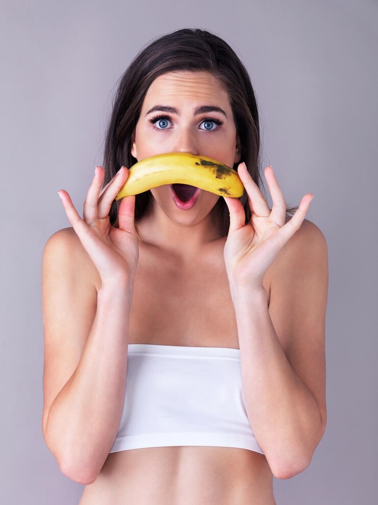 Foto bigode de banana e retrato de mulher para choque surpresa e notícias em estúdio dermatologia wow e expressão facial com frutas em fundo para cuidado da pele natural bem-estar e beleza orgânica