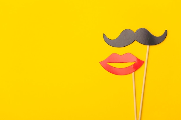 Bigode e lábios em uma vara em um fundo amarelo brilhante