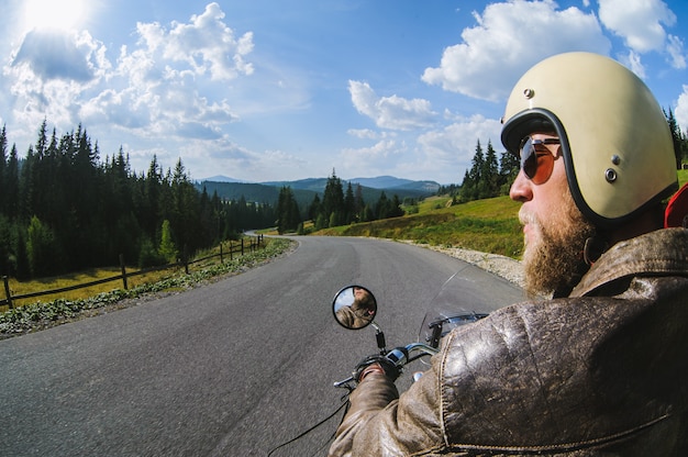 Biker conduciendo su moto por carretera.