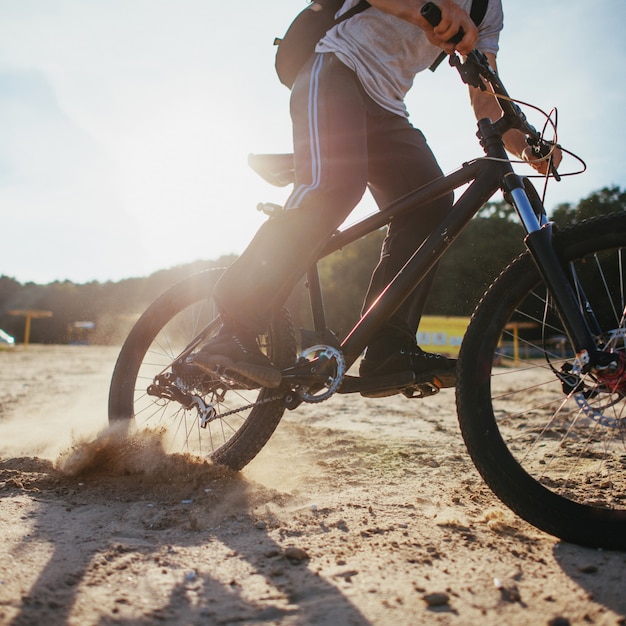 Biker, der am Strand bei Sonnenuntergang reitet