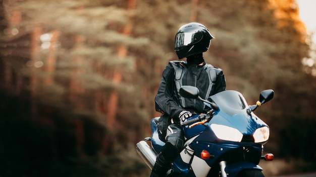 Biker im Schutzanzug mit Helm. Motorradfahrer in Helm und Lederjacke auf einem Sportmotorrad unterwegs