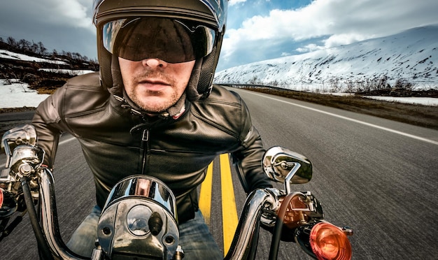 Biker in Helm und Lederjacke, die auf der Straße rennen.