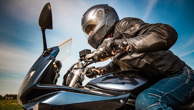 Biker in Helm und Lederjacke, die auf der Straße rennen.