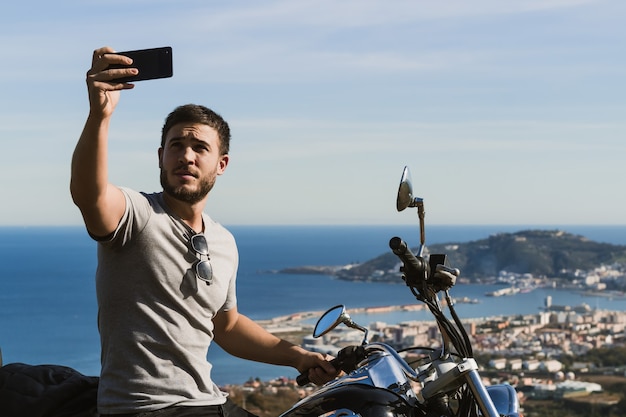 Biker macht ein Selfie mit der Landschaft während einer Route